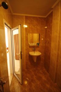a bathroom with a sink and a mirror and a shower at Hotel Marant in Sozopol