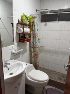 a bathroom with a toilet and a sink at CasaHotel Chaclacayo in Chaclacayo
