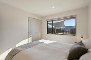 a bedroom with a bed with a large window at Vista Vale - Wanaka Holiday Home in Wanaka