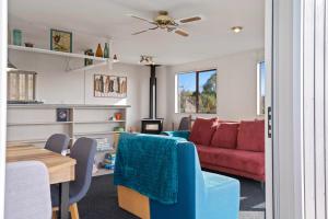 un salon avec un canapé et une table dans l'établissement Serenity Lakehouse - Rotorua Holiday Home, à Rotorua