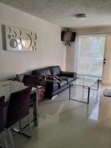Una sala de estar con un sofá y una mesa de cristal. en Casa Flamingo 3 Recamaras, 3 Baños completos, en Ixtapa
