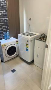 a washing machine and a sink in a room at Colebee5 BR house near park and shop in Schofields