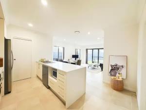 a white kitchen with a counter and a desk at Colebee5 BR house near park and shop in Schofields