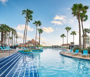 a pool at the resort with palm trees at Margaritaville Beach Resort South Padre Island in South Padre Island