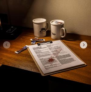 two coffee cups and a book on a table at Alice Hotel in Suwon