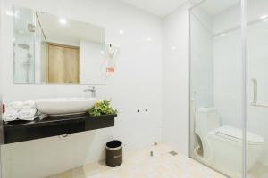 een witte badkamer met een wastafel en een toilet bij Ivy Luxury Hotel Ha Noi in Hanoi +22 foto's