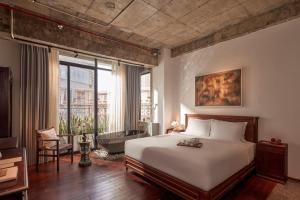 a bedroom with a large bed and a large window at ANIMA Vietnamese Contemporary Art Boutique Hotel in Ho Chi Minh City