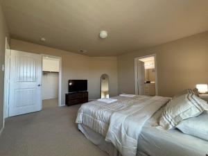 una camera da letto con un letto grande e una TV a schermo piatto di Modern & Comfy 4-Bedroom Home with King Bed, Workspace, & Fast Wi-Fi a Princeton