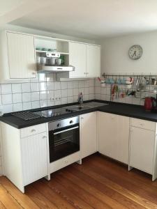 a kitchen with white cabinets and black counter tops at SEELIG`S in Weinsheim