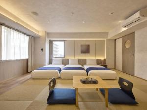 a bedroom with two beds and a table at Village Kyoto in Kyoto