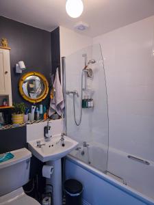 Un baño con lavabo, inodoro y ducha. en Bright Double Room in Leith - Near Tram & Shore, en Edimburgo