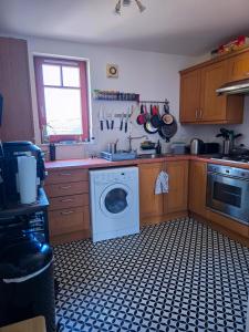 a kitchen with a washing machine and a window at Leith Double Rooms in Shared Flat Near The Shore and Tram in Edinburgh +15 photos