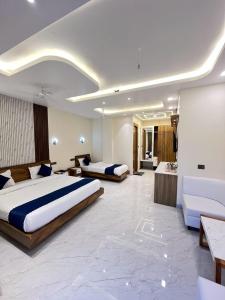 a hotel room with two beds and a couch at Hotel Buransh inn Ghugtani secret Waterfall Road Tapovan Rishikesh in Rishīkesh