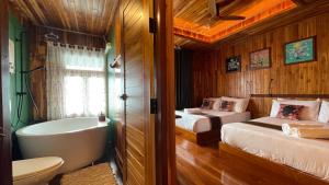 a bathroom with two beds and a bathtub and a bathroom with two beds at The Floating Lake House in Ban Pracham Mai Bon