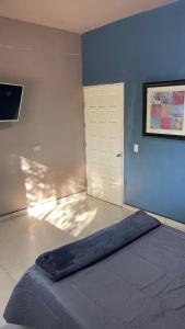 a blue room with a bed and a door at Casa Marlin in Mulegé