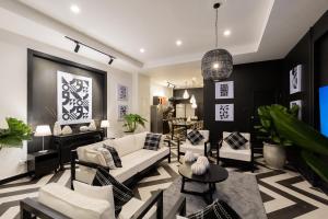 a living room with white furniture and a pendant light at Nimman Nest AndLae Living in Chiang Mai