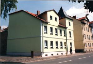 duży biało-zielony budynek po stronie ulicy w obiekcie Apartments Röhrstraße w mieście Weimar