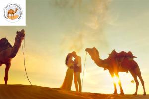斋沙默尔Best Desert camp sam sand dunes Jaisalmer的沙漠中，一男一女站在骆驼旁边