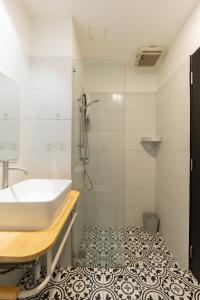a white bathroom with a sink and a shower at Nimman Nest AndLae Living in Chiang Mai