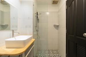 a white bathroom with a sink and a shower at Nimman Nest AndLae Living in Chiang Mai