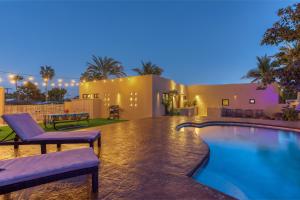 a swimming pool with two chairs and a house at Hotel Hondo in Los Barriles