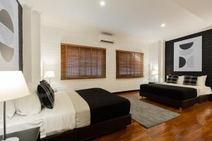 a bedroom with two beds and a couch at Nimman Nest AndLae Living in Chiang Mai