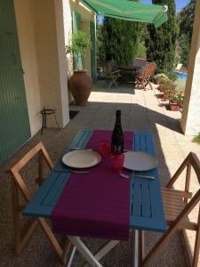 Una mesa azul con una botella de vino. en Les Mimosas Apartments, en Villelongue-dels-Monts