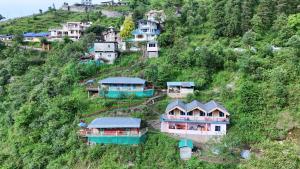 a group of houses on the side of a hill at The Mud house, Mussoorie in Mussoorie