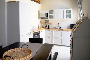 Una cocina con gabinetes blancos y una mesa de madera. en SimoArnoHome, en Cagliari