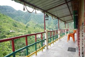 a balcony with a view of the mountains at The Mud house, Mussoorie in Mussoorie
