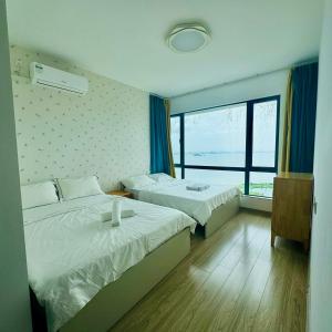 a hotel room with two beds and a window at Seaview 2B2R 6pax Forest City C5-2404 in Gelang Patah