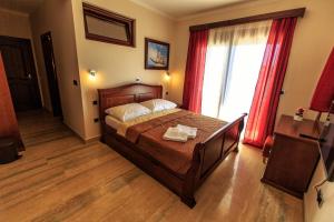 a bedroom with a bed and a large window at Compass Aparthotel in Dobra Voda