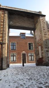 een groot bakstenen gebouw met een grote deuropening bij Hotel Guesthouse Begijnhof in Leuven