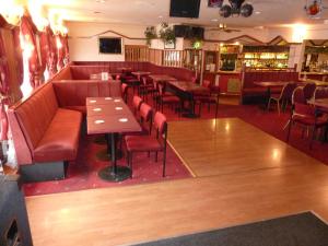 a restaurant with a couch and tables and chairs at The Mercury in Bolton