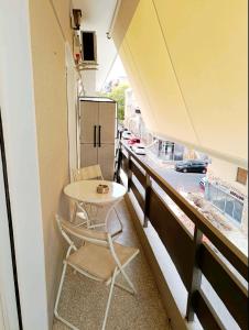 a small table and two chairs on a balcony at Thissio Hideaway Suite in Athens