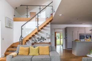 a living room with a couch and a staircase at Mayflower lakeside hot tub in South Cerney