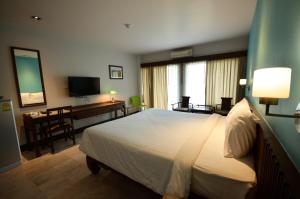 a hotel room with a bed and a desk at Sakorn Residence and Hotel in Chiang Mai