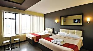 a hotel room with two beds and a mirror at Express Inn Cebu Mabolo in Dita