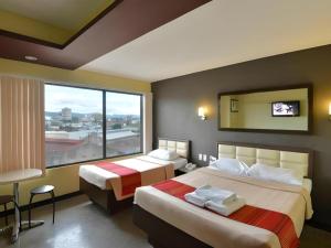 een hotelkamer met twee bedden en een groot raam bij Express Inn Cebu Mabolo in Mabolo +128 foto's