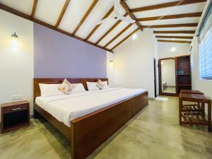 a bedroom with a large bed in a room at PEKOE VALLEY Huluganga in Huluganga +19 photos