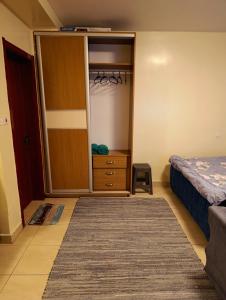 1 dormitorio con armario, cama y vestidor en City view studio 1D, en Nairobi