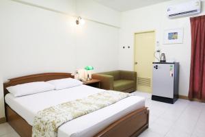 Un dormitorio con una cama y una silla en una habitación. en Phawana Sweet Hotel, en Bangkok