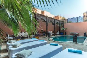 un grupo de colchones sentados junto a una piscina en Villa amira et spa, en Marrakech