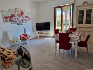 a living room with a table and chairs and a television at Casa di Tea costa etrusca piombino in Piombino