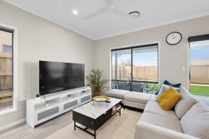 Una sala de estar con un televisor de pantalla plana grande. en Griffin Family Stay 4BR New Home, en Griffin