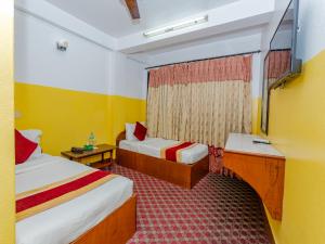 a hotel room with two beds and a mirror at Oyo 807 Hotel Grand Tokyo in Kathmandu +6 photos