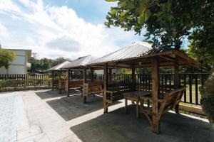 a group of picnic tables with a metal roof at OYO 1152 Hotel Precious Garden Place in Indang