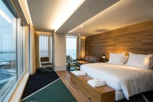a bedroom with a large bed and a large window at Octant Ponta Delgada in Ponta Delgada
