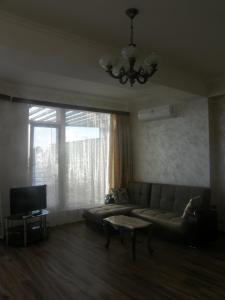 sala de estar con sofá y ventana grande en Apartments near the Sea, en Ureki