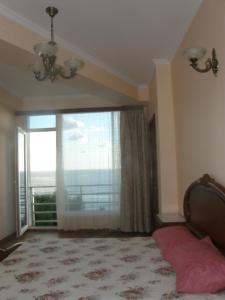 1 dormitorio con cama y ventana grande en Apartments near the Sea, en Ureki